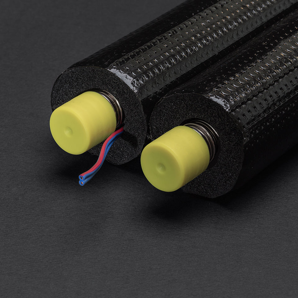 Close-up of a black cylindrical object with yellow ends on a dark background