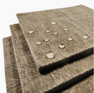 A stack of ArmaGel XGH Insulation Blankets showcasing their fibrous, beige surface with water droplets beading on top, highlighting the material's hydrophobic properties. Available at Pipelagging.com